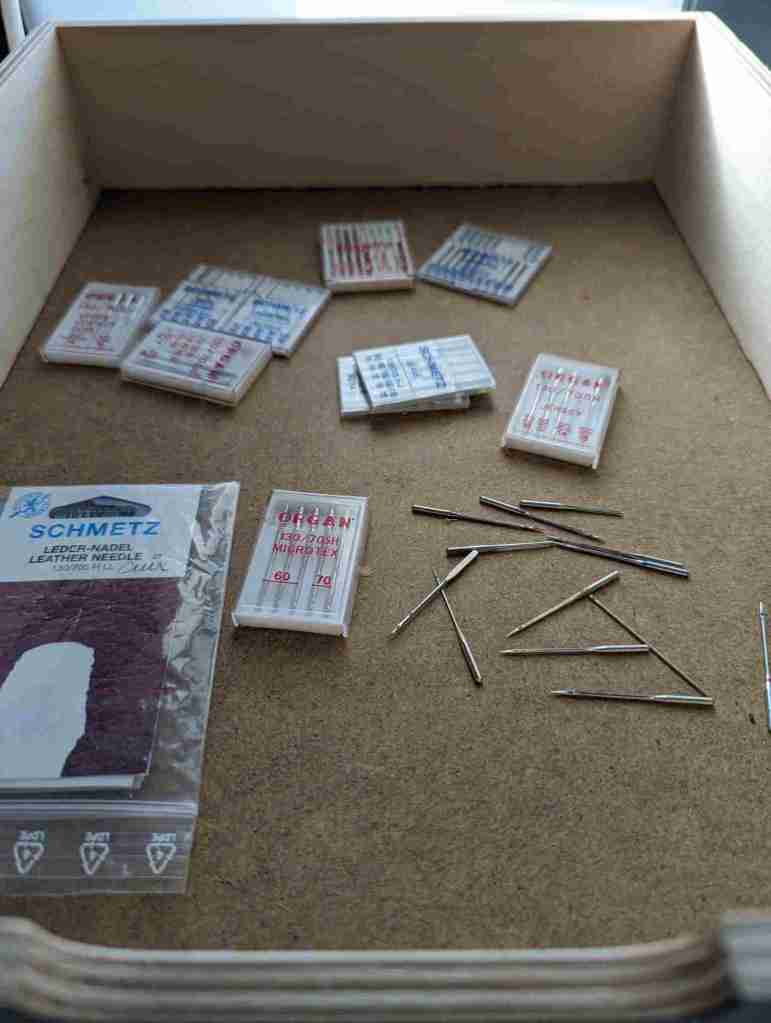 Des aiguilles de machine à coudre dans un tiroir