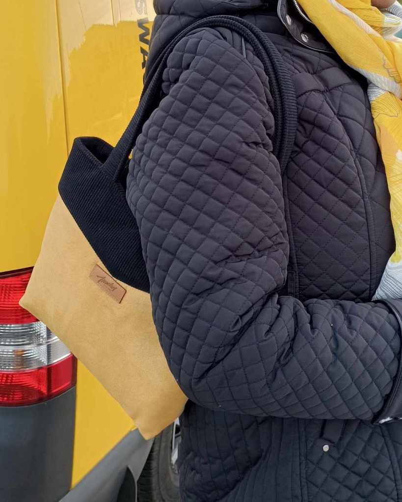 Sac à main tissu jaune et noir porté à l'épaule