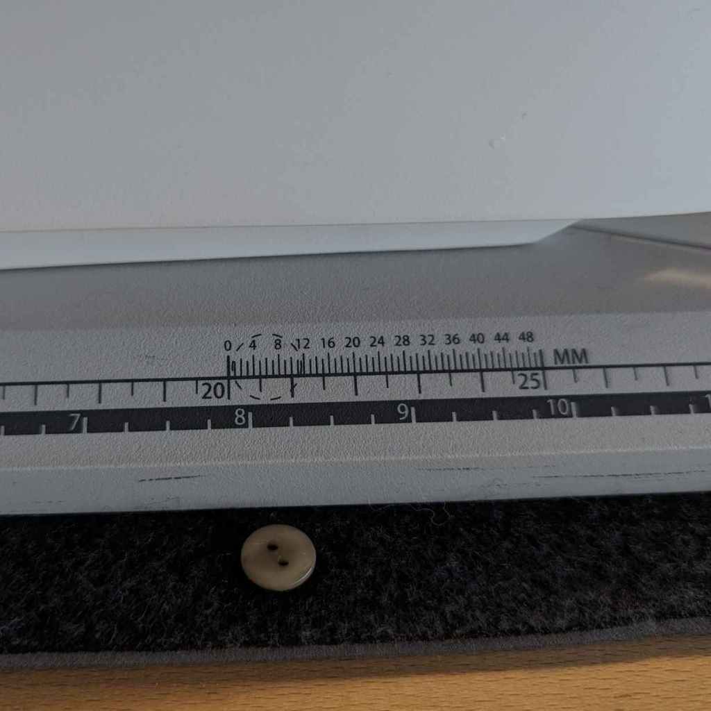 une règle à boutons sur le socle d'une machine à coudre