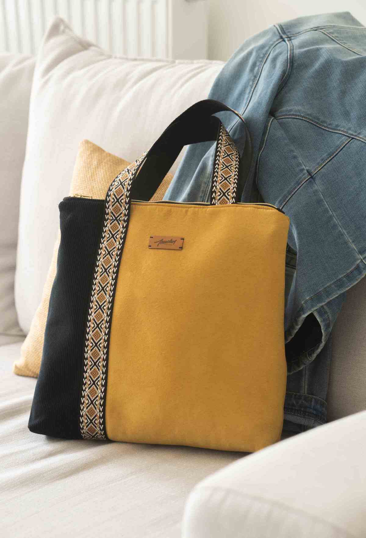 sac tissu noir et jaune posé sur un canapé