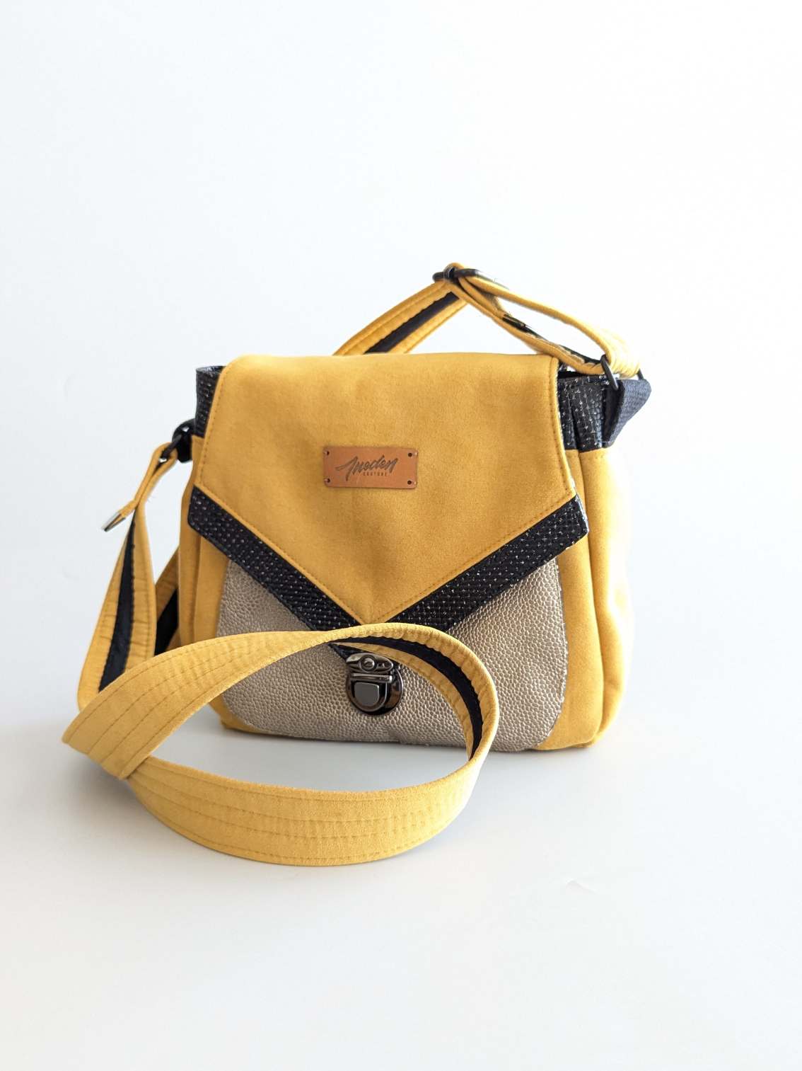 Sac bandoulière tissu jaune, simili argenté, détails noirs, rabat avec fermoir écolier.